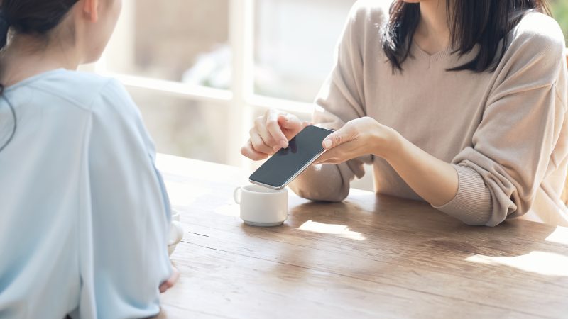 スマホを見せる女性